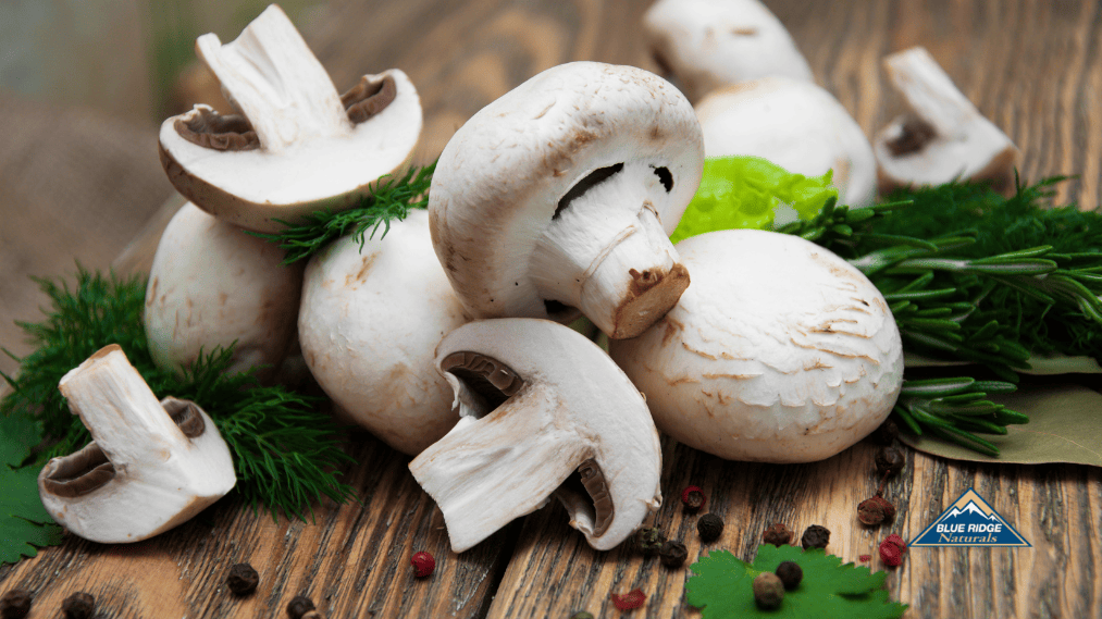 Sliced mushrooms with green leaves on a wooden chopper.